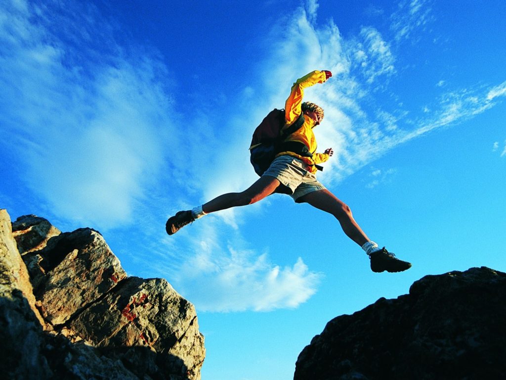 person jump across gap in rocks