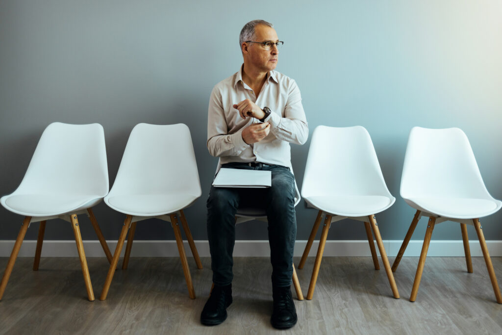 A mature man sitting in a waiting room